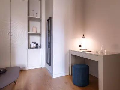 a living room with a desk and a blue stool at Numa Valencia La Xerea in Valencia