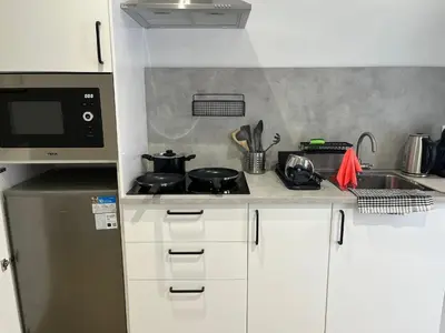 a small kitchen with a stove and a microwave at Quiet room in a park close to the sea & beach & subway No-4 in Valencia