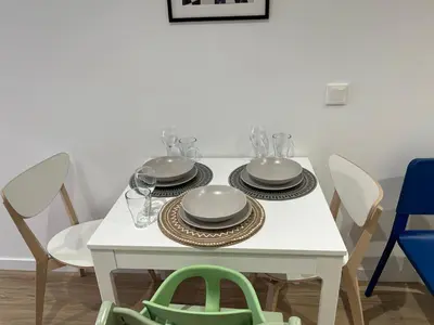 a white table with plates and wine glasses on it at Quiet room in a park close to the sea & beach & subway No-4 in Valencia