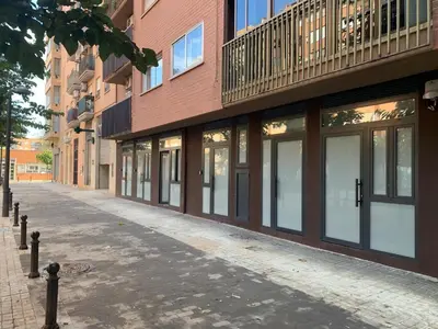 an empty street in front of a brick building at Quiet room in a park close to the sea & beach & subway No-4 in Valencia