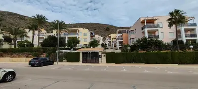 a parking lot with palm trees and buildings at Apto en Cullera con terraza, piscina, parking y wifi gratis in Cullera