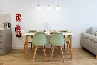 a dining room table with four green chairs at Main Lofts Valencia in Valencia