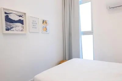 a bedroom with a white bed and two pictures on the wall at Main Lofts Valencia in Valencia