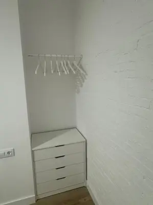 a white closet with a dresser and a brick wall at Gran apartamento a pie de calle in Valencia