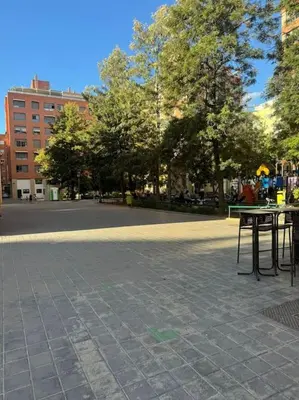 a park with tables and trees on a street at Gran apartamento a pie de calle in Valencia