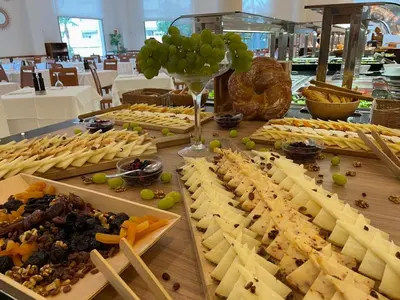 a table filled with different types of cheese and grapes at Hotel Santamarta in Cullera