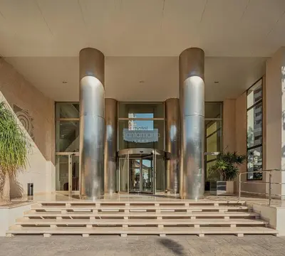 a lobby of a building with stainless steel columns at Hotel Santamarta in Cullera