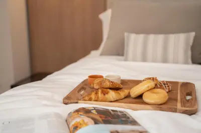 a tray of bread and pastries on a bed at Calderona Wellness in Bétera