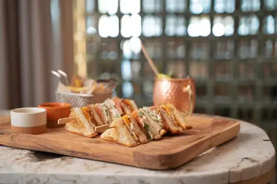 a wooden cutting board with sandwiches on a table at Calderona Wellness in Bétera