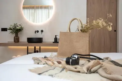a camera and a bag on a bed at Nomad Haux Mestalla in Valencia