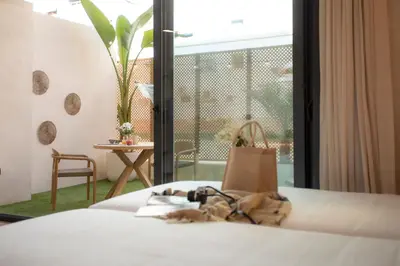 a bedroom with a bed and a table and a window at Nomad Haux Mestalla in Valencia