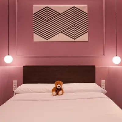 a teddy bear sitting on top of a bed at Osito Hub - Llorens in Valencia