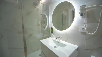 a white bathroom with a sink and a mirror at Hotel Sleep Turia music & art in Lliria