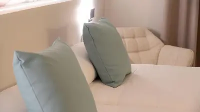 a white couch with two pillows and a chair at Hotel Sleep Turia music & art in Lliria