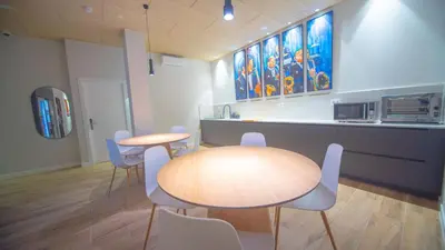 a room with two tables and chairs and a kitchen at Hotel Sleep Turia music & art in Lliria