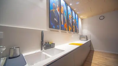a kitchen with a sink and some paintings on the wall at Hotel Sleep Turia music & art in Lliria
