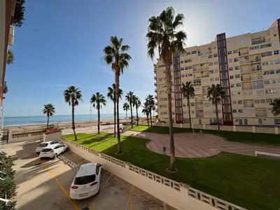 a parking lot with cars parked in front of a building at Sun & Sea Cullera in Cullera