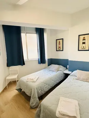 a bedroom with two beds and a window at Sun & Sea Cullera in Cullera