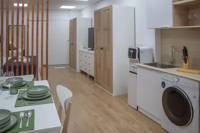 a kitchen with a table and a washing machine at Acogedor estudio en el Centro de Valencia in Valencia
