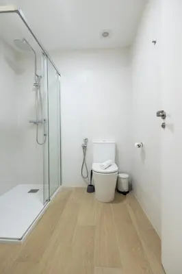 a bathroom with a toilet and a glass shower at Imprenta Sorolla by Concept in Valencia