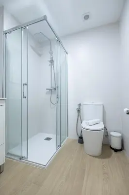 a bathroom with a glass shower and a toilet at Imprenta Sorolla by Concept in Valencia