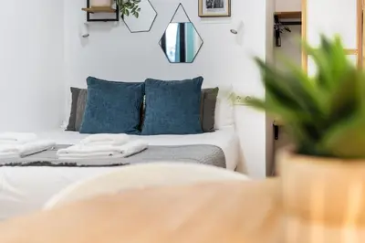 a bedroom with a white bed with blue pillows at VLC HOST - Ausias March in Valencia