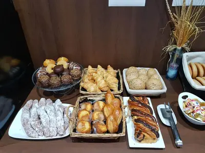 a table topped with trays of different types of pastries at Hotel Olympia Universidades in Valencia