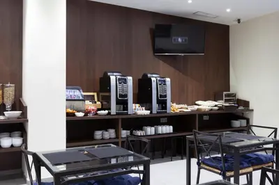a coffee shop with two machines on a counter at Hotel Olympia Universidades in Valencia