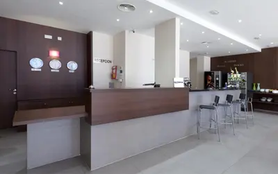 a restaurant with a counter and stools in a room at Hotel Olympia Universidades in Valencia