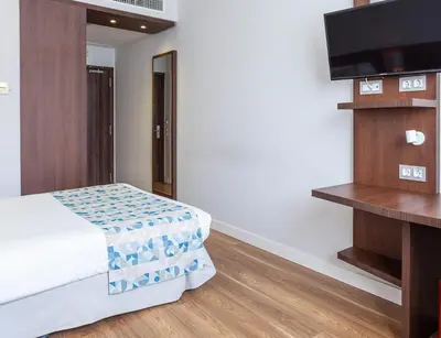 a bedroom with a bed and a flat screen tv at Hotel Olympia Universidades in Valencia