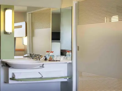 a bathroom with a sink and a mirror at Ibis Budget Valencia Alcasser in Silla