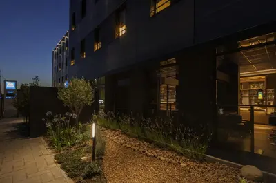 a black building with windows and flowers in front of it at Ibis Budget Valencia Alcasser in Silla