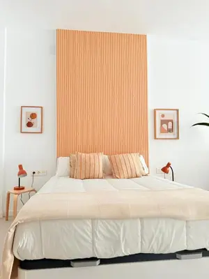 a bedroom with a large bed with an orange wall at Loft Taronja Ruzafa-Parque central in Valencia