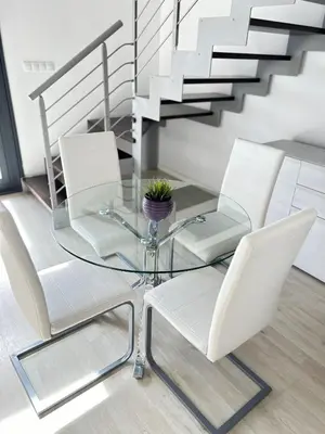 a glass table with white chairs and a staircase at Mi Huésped Valencia, Aeropuerto Manises in Manises