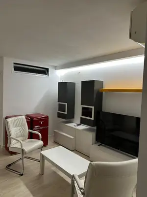 a living room with a couch and chairs and a television at Mi Huésped Valencia, Aeropuerto Manises in Manises