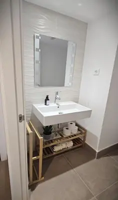 a bathroom with a white sink and a mirror at Apartamento Ciudad de Las Ciencias - Apartamento Ciudad de Les Arts in Valencia