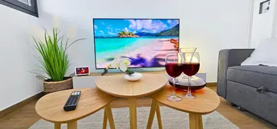 a living room with two glasses of wine and a television at Apartamento Ciudad de Las Ciencias - Apartamento Ciudad de Les Arts in Valencia