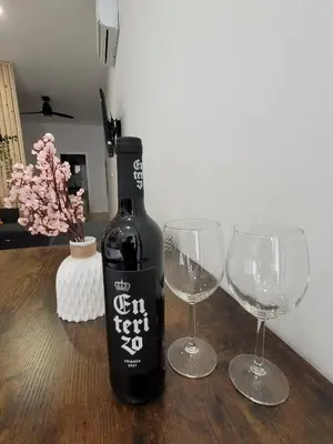 a bottle of wine and two wine glasses on a table at Apartamento loft con encanto Suite Home Valencia in Valencia