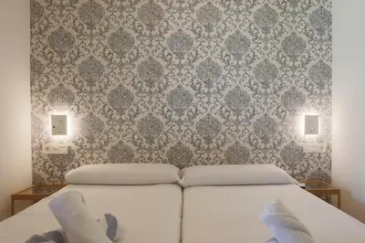 a bedroom with a white bed with a patterned wall at Fantasy Villa Valencia - Airport & Circuit Ricardo Tormo in Chiva