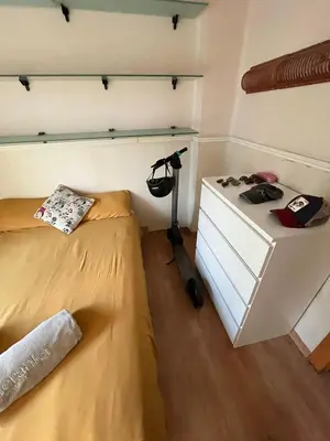 a bedroom with a bed and a dresser with a lamp at Precioso apartamento al lado de la Ciudad de las Artes in Valencia