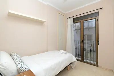 a white bedroom with a bed and a window at GuestReady - Urban retreat in Valencia in Valencia