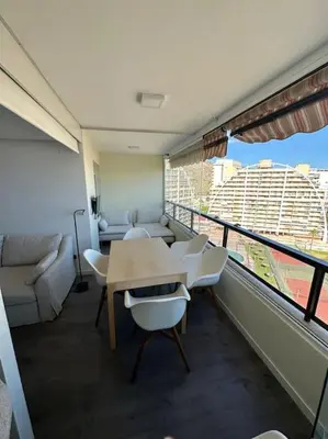 a room with a table and chairs and a balcony at Apto con encanto en primera línea de playa , Cullera in Cullera