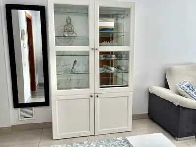 a white cabinet with glass doors in a living room at Valencia Beach Home 22 in Valencia