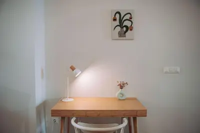 a wooden desk with a lamp and a white chair at Apartamento junto a Ruzafa in Valencia