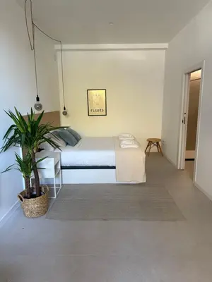 a bedroom with a bed and a potted plant at Loft Mar Ruzafa-Parque central in Valencia