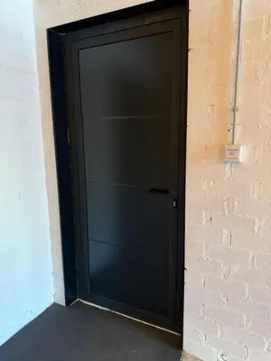 a black garage door in a brick wall at Loft Mar Ruzafa-Parque central in Valencia