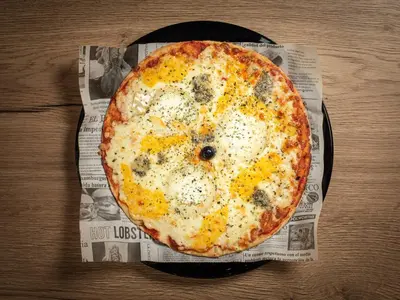 a pizza sitting on top of a plate on a table at Plaza Alaquas in Alaquas