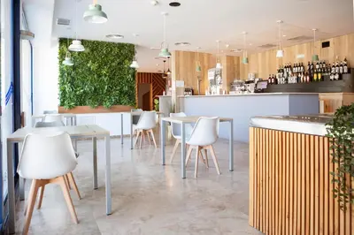 a restaurant with white chairs and tables and a bar at Plaza Alaquas in Alaquas