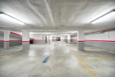 an empty parking garage with red and white columns at Plaza Alaquas in Alaquas