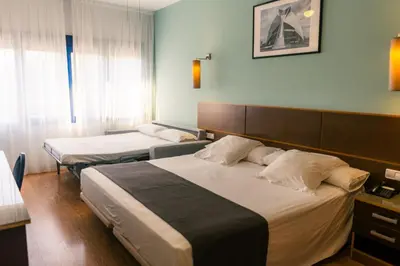a hotel room with two beds and a window at Plaza Alaquas in Alaquas
